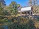 Charming two-story home with a metal roof and covered porch, nestled among a lush landscape, provides a serene escape at 13524 Corkwood Ln, Astatula, FL 34705