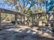 Open garage with concrete walls, offering ample space for parking and storage, overlooking greenery beyond at 13524 Corkwood Ln, Astatula, FL 34705
