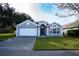 One-story house with a two-car garage, dark brown front door, and manicured lawn at 3103 Merlot Way, Clermont, FL 34714