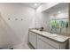 Bright bathroom featuring double sinks, a large mirror, and a playful shower curtain at 2720 Dumont Ln, Tavares, FL 32778