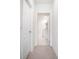 Hallway with neutral tones leading to a pristine bathroom, showcasing a clean design at 2720 Dumont Ln, Tavares, FL 32778