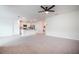 Spacious living room with neutral carpet, ceiling fan, and an open kitchen at 2720 Dumont Ln, Tavares, FL 32778