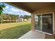 Covered patio with serene views of a pond and lush green lawn at 2720 Dumont Ln, Tavares, FL 32778