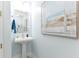 Chic powder room with pedestal sink, decorative mirror, and beach-themed art at 4624 Harbour Village Bv # 4205, Ponce Inlet, FL 32127