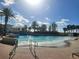 Resort-style pool with wave feature, palm trees, and ample lounge space at 8495 Miracle Dr # 202, Champions Gate, FL 33896