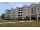 Tan multi-story building with balconies and landscaped grounds at 8495 Miracle Dr # 202, Champions Gate, FL 33896