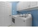 Laundry room with washer, dryer, and upper cabinets at 2441 Prairie Dunes, Clermont, FL 34711