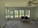 Bright sunroom features plenty of natural light, a ceiling fan, and views of the wooded backyard at 32676 Oak Park Dr, Leesburg, FL 34748