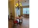 Cozy dining area features wood floors and a stylish chandelier at 439 Grovewood Pl, The Villages, FL 32162