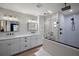 Modern bathroom with double vanity, white cabinets and quartz countertops, with a large walk-in shower at 1635 Hilltop Dr, Mount Dora, FL 32757