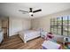 Bedroom features wood floors, a ceiling fan, closet space, and a bright window, perfect for a room at 1635 Hilltop Dr, Mount Dora, FL 32757