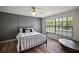 Comfortable bedroom with stylish decor, ceiling fan, and a large window overlooking the landscape at 1635 Hilltop Dr, Mount Dora, FL 32757