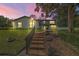 Lovely two-story home with a brick-laid path and manicured landscaping illuminated at dusk at 1635 Hilltop Dr, Mount Dora, FL 32757