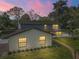 Rear view of two-story house at dusk, with painted brick and lush green landscaping at 1635 Hilltop Dr, Mount Dora, FL 32757