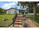 Beautiful two-story home with white brick, a well-manicured lawn, and a stone stairway at 1635 Hilltop Dr, Mount Dora, FL 32757