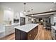 Open kitchen with large island, white cabinets, and stainless steel appliances, with views of living room at 1635 Hilltop Dr, Mount Dora, FL 32757