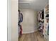 Walk-in closet with wood floors, white shelving, and ample storage space for clothes and accessories at 1635 Hilltop Dr, Mount Dora, FL 32757