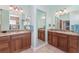 Luxury bathroom with dual sinks, wooden cabinetry, and a framed mirror at 1786 Red Clover Ln, The Villages, FL 32163