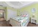 Bright bedroom featuring tropical bedding, wood floors, ceiling fan, and ample closet space at 1786 Red Clover Ln, The Villages, FL 32163
