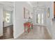 Inviting foyer with decorative console table, mirror, and tiled flooring at 1786 Red Clover Ln, The Villages, FL 32163