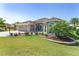 Beautiful single-story home showcasing a lush lawn, landscaping, and a welcoming entrance at 1786 Red Clover Ln, The Villages, FL 32163
