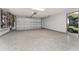 Spacious three-car garage with epoxy flooring, storage racks, and golf cart parking at 1786 Red Clover Ln, The Villages, FL 32163