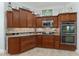 Cherry wood cabinets and stainless appliances accent this spacious kitchen design at 1786 Red Clover Ln, The Villages, FL 32163