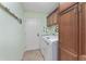Functional laundry room with washer, dryer, storage cabinets, and access to the exterior at 1786 Red Clover Ln, The Villages, FL 32163