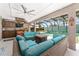 Outdoor screened pool area featuring comfortable seating, a tiki bar, and a ceiling fan at 1786 Red Clover Ln, The Villages, FL 32163