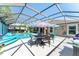 Inviting screened-in pool area with outdoor dining set, perfect for enjoying meals by the water at 1786 Red Clover Ln, The Villages, FL 32163