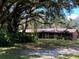 Brick home with a landscaped front yard and large shade trees, offering a blend of comfort and nature at 1921 Smitty Rd, Lady Lake, FL 32159