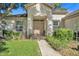 Inviting home exterior with a well-manicured lawn, lush landscaping, and a charming double-door entrance at 12176 Se 91St Ave, Summerfield, FL 34491