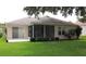 View of the back of the home with a screened lanai and green grass at 4953 Glen Coe St, Leesburg, FL 34748