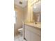 Bright bathroom with a single vanity, white cabinets and a framed mirror at 4953 Glen Coe St, Leesburg, FL 34748
