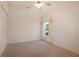 This carpeted bedroom offers a window, closet and ceiling fan at 4953 Glen Coe St, Leesburg, FL 34748