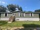 Single-wide manufactured home with wood siding and steps at 4422 Cr 690, Webster, FL 33597