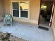 Inviting front porch with a comfortable chair and welcome mat at 5596 Cedar Waxwing Dr, The Villages, FL 32163