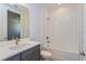 Bathroom with gray vanity, white tile, and bathtub at 10125 Gobat Aly, Orlando, FL 32827