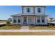 Two-story home with light-gray siding, blue shutters, and a metal roof at 10125 Gobat Aly, Orlando, FL 32827