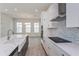 Modern kitchen with white cabinets, quartz countertops, and a farmhouse sink at 10125 Gobat Aly, Orlando, FL 32827