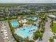 Extensive aerial view of the community pools with lounge seating, umbrellas, and lush landscaping at 10218 Dulbecco St, Orlando, FL 32827