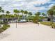 Community sand volleyball court with a red net, palm trees, and clubhouse in the background at 10218 Dulbecco St, Orlando, FL 32827