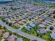 Expansive aerial shot of a golf community with homes surrounded by lush landscaping and winding roads at 1751 Ashwood Run, The Villages, FL 32162