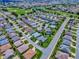 A panoramic aerial view exhibits a neighborhood featuring beautiful landscaping close to golf courses and lakes at 1751 Ashwood Run, The Villages, FL 32162