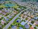 A high-definition aerial view shows a neighborhood with beautiful landscaping near a golf course and lakes at 1751 Ashwood Run, The Villages, FL 32162