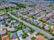 A breathtaking aerial view exhibits a sprawling neighborhood with attractive landscaping, golf courses, and tranquil lakes at 1751 Ashwood Run, The Villages, FL 32162