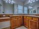 Bathroom featuring double sinks, wood cabinets and vanity space, and large mirrors at 1751 Ashwood Run, The Villages, FL 32162