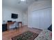 Functional bedroom with a desk, TV, hardwood floors, and closet storage at 1751 Ashwood Run, The Villages, FL 32162
