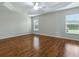 Spacious bedroom with wood flooring, ceiling fan, and natural light from two windows at 1751 Ashwood Run, The Villages, FL 32162