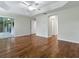 A bedroom with wood floors and a ceiling fan has access to outdoor space through sliding glass doors at 1751 Ashwood Run, The Villages, FL 32162